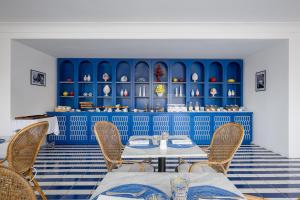 a restaurant with blue walls and tables and chairs at Villa Lia Hotel Capri in Capri