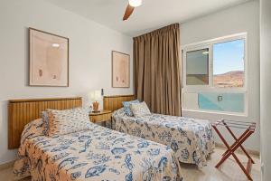 a hotel room with two beds and a window at Callao Beach 7 in Arrieta +18 photos