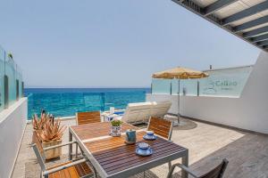 a patio with a table and chairs and the ocean at Callao Beach 7 in Arrieta