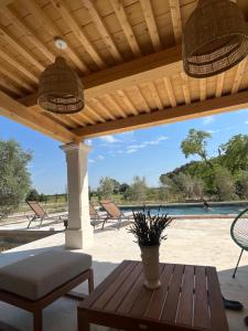a patio with a table and chairs and a pool at Mas Belvega in La Baume-de-Transit