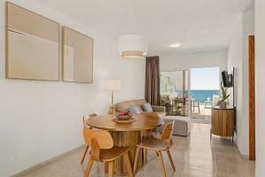 a living room with a dining room table with a view of the ocean at Callao Beach 7 in Arrieta