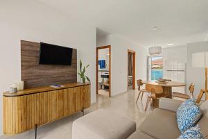 a living room with a couch and a tv on a wall at Callao Beach 7 in Arrieta