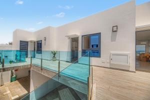 a house with a glass balcony with a swimming pool at Callao Beach 7 in Arrieta