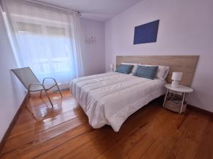 a bedroom with a large bed and a wooden floor at Apartamento ARBEA in Ochagavía