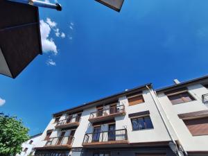 a white building with balconies and a blue sky at Apartamento ARBEA in Ochagavía