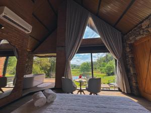 a bedroom with a bed and a large window at Guest house Etérea in Flores da Cunha