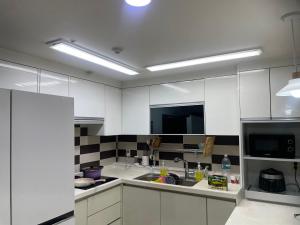 a kitchen with white cabinets and a sink at 외국인여성전용게스트하우스 in Pup'yŏng-yŏk +193 photos