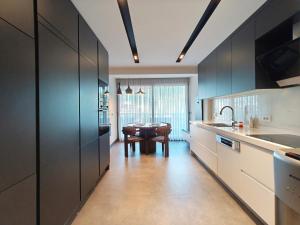 a kitchen with black cabinets and a table in it at Utopia Suite Residence - 4 Bedroom Apartment in Burunabat