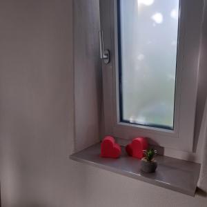 two red hearts sitting on a shelf next to a window at Eichkobel-Blick in Grünenbach +23 photos