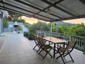 a wooden table and chairs on a patio at Villa tusia in Vravrona