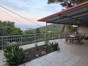 a patio with a table and chairs on a balcony at Villa tusia in Vravrona +5 photos