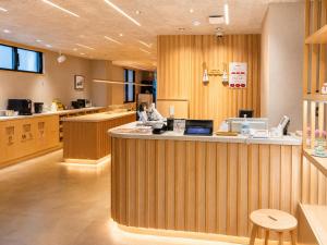 a restaurant with a counter and a kitchen with at 女性専用 Woman Only capsule MAJA HOTEL KYOTO マヤホテルキョウト in Kyoto