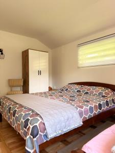 a bedroom with a bed and a window at Kuca za odmor SONATA in Biserske Kuće