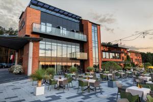 a restaurant with tables and chairs in front of a building at Hotel Duo Spa in Janów Lubelski