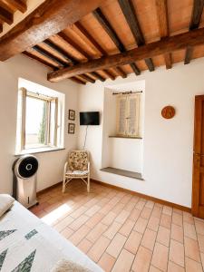 a bedroom with a bed and a chair in a room at La Piccola dimora in Gambassi Terme