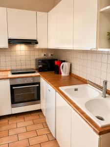 a kitchen with white cabinets and a sink at La Piccola dimora in Gambassi Terme +2 photos