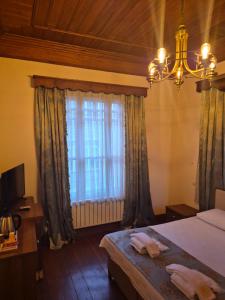 a bedroom with a bed and a window and a chandelier at Ali Paşa Konağı Sarıyer in Sarıyer