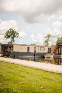 a boat is parked next to a river at The Creative Boat - Sneekermeer in Offingawier