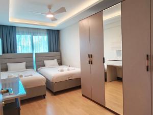 a bedroom with two beds and a sliding glass door at Utopia Suite Residence - 4 Bedroom Apartment in Burunabat +30 photos