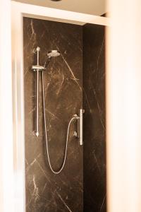 a shower in a bathroom with a marble wall at The Creative Boat - Sneekermeer in Offingawier +43 photos