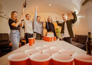 a group of people standing around a table with their hands in the air at Wombat's City Hostel Budapest in Budapest +40 photos