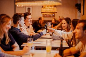 a group of people sitting around a table drinking wine at Wombat's City Hostel Budapest in Budapest