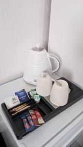 a shelf in a refrigerator with a tea pot and cups at Ocean Breeze Inn in Eyemouth