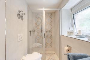 a shower with a glass door in a bathroom at Villa Rosa in Offenburg +17 photos