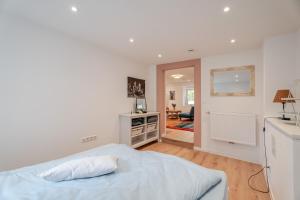 a white bedroom with a bed and a living room at Villa Rosa in Offenburg