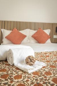 a bed with a pile of towels and a basket on it at Melissa's house in Amora