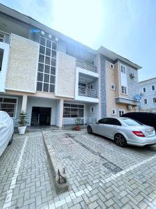 a white car parked in front of a building at Jahi Luxe apartment in Gwarinpa