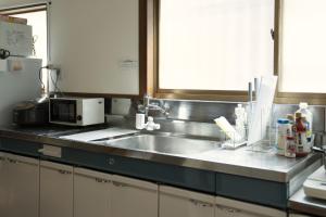 a kitchen counter with a sink and a microwave at 大磯シーサイドハウス 海まで2分 駅近の一軒家 in Oiso