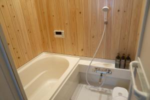 a small bathroom with a tub and a shower at 大磯シーサイドハウス 海まで2分 駅近の一軒家 in Oiso