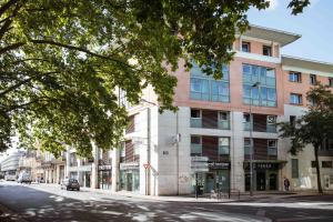 a building on the corner of a street at Ténéo Apparthotel Bordeaux - Gare Saint Jean in Bordeaux