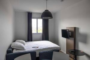 a small room with a bed and a tv at Ténéo Apparthotel Bordeaux - Gare Saint Jean in Bordeaux