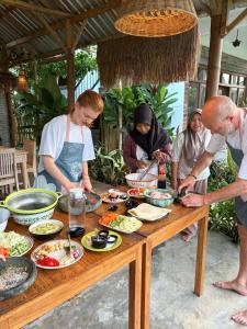 a group of people standing around a table with food at Stay Together in Tetebatu