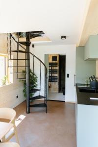a kitchen with a spiral staircase in a house at OFF Living Charlet in Pirching am Traubenberg