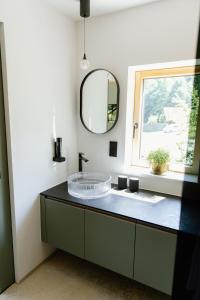 a bathroom with a sink and a mirror at OFF Living Charlet in Pirching am Traubenberg