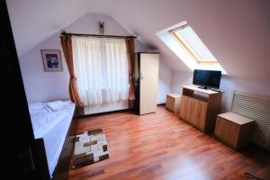 a small room with a bed and a television at Vila Residence in Moieciu de Sus