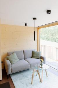 a living room with a couch and a glass table at OFF Living Charlet in Pirching am Traubenberg