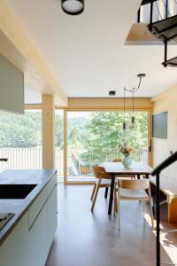 a kitchen and dining room with a table and a large window at OFF Living Charlet in Pirching am Traubenberg