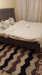 a bed in a bedroom with a zebra print rug at Urban Pulse Suites in Ruiru