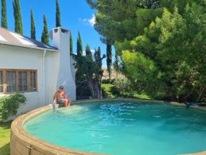 a man sitting in a large swimming pool at Konka Guest Farm in Carnarvon