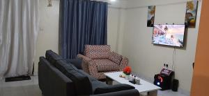 a living room with a couch and a chair at Urban Pulse Suites in Ruiru +2 photos