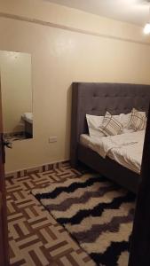 a bedroom with a bed with a mirror and a rug at Urban Pulse Suites in Ruiru