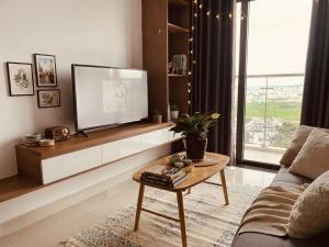 a living room with a tv and a coffee table at Ina apartment - Nera garden Hue in Hue