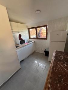 a small kitchen with a refrigerator and a microwave at myappart - FORBACH in Forbach