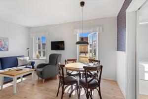 a living room and dining room with a table and chairs at Løkken Badehotel Apartments in Løkken
