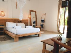 a bedroom with a bed and a mirror at Ethera Arugam bay in Arugam Bay