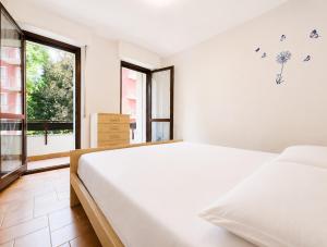 a white bedroom with a large bed and a window at Bella Vita Stays Easy in Sondrio